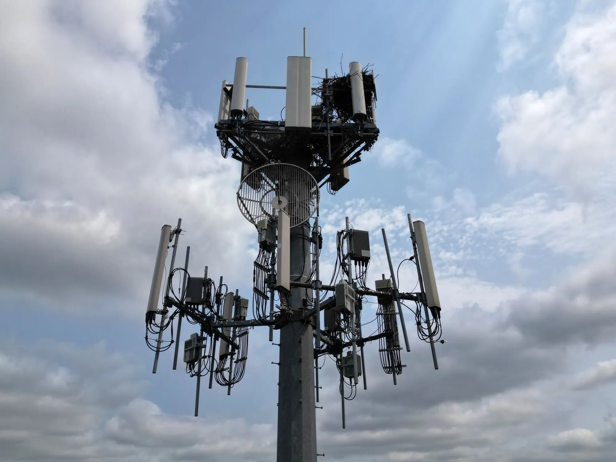 Monopole mobile site with sector antennas against cloud