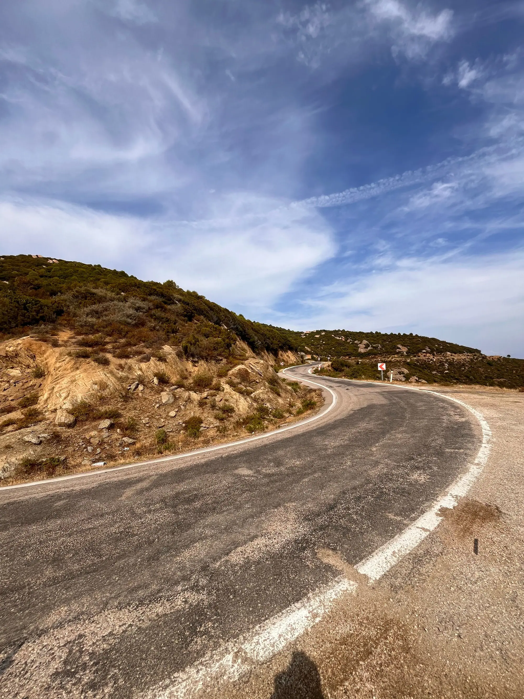 Winding two-lane road across dry hills